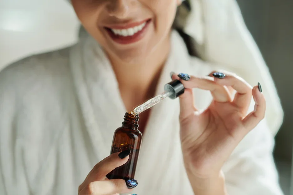 a woman is holding a bottle of pdrn caffeine shot serum