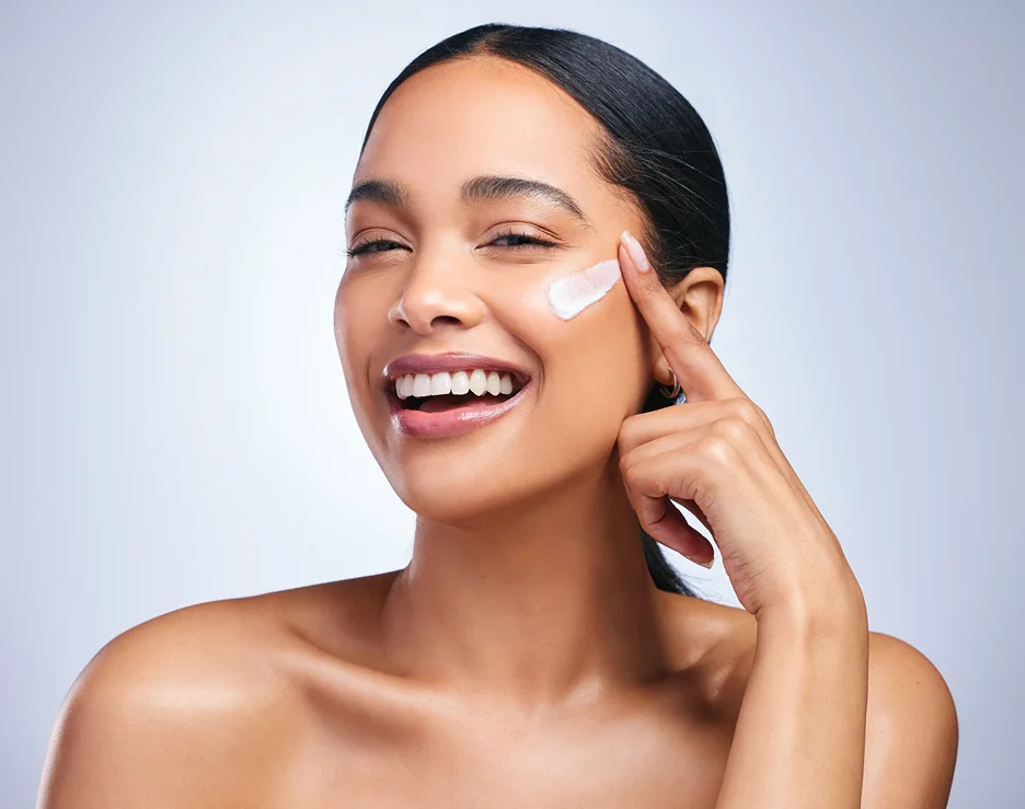 a portrait of a woman applying moisturizer with salmon sperm dna on her face