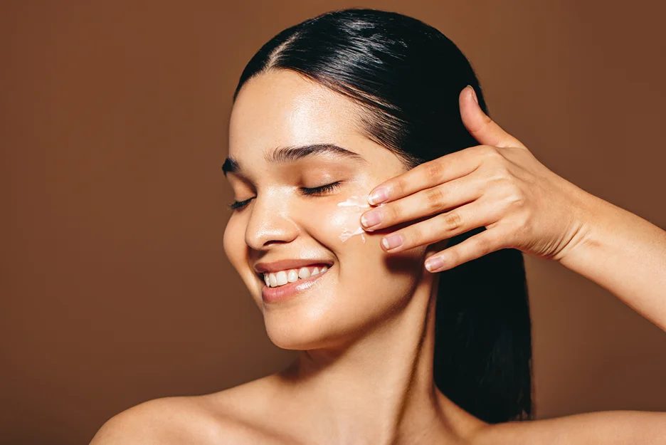 a young woman applies pdrn essence on her face