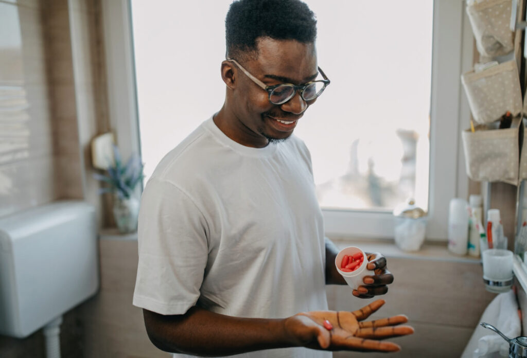 Young man takes vitamin in the morning