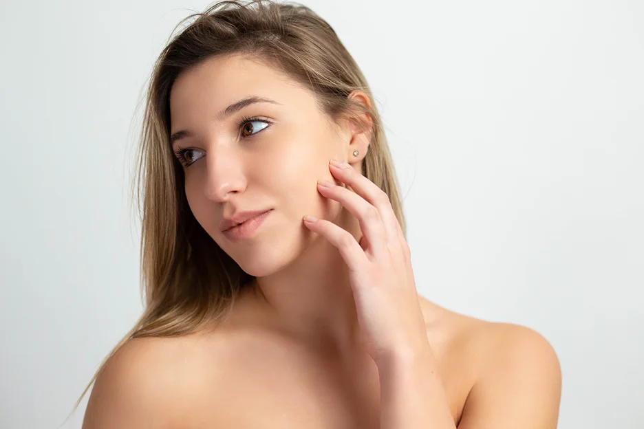 a portrait of a woman with glowing skin post-microneedling procedure